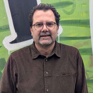 Mann mit dunkler Haaren, Brille und Bart