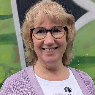 Frau mit blonden Haaren und Brille